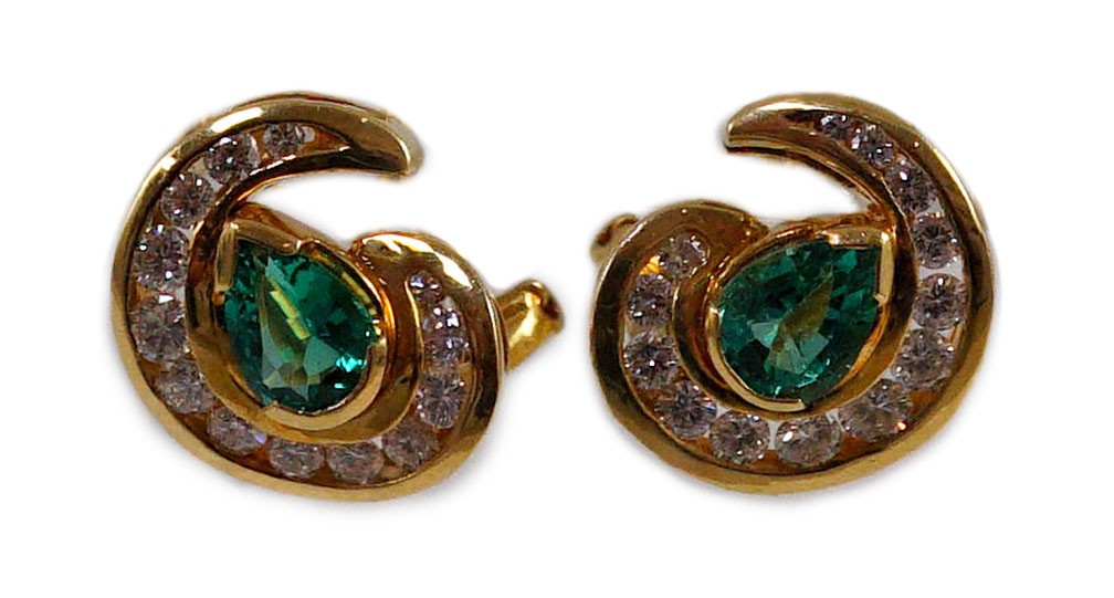 A modern pair of gold (tests as 18ct), emerald and diamond set scrolling cluster earrings
